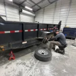 Technician servicing a dump trailer wheel